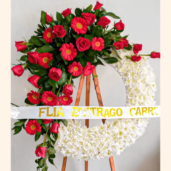 Corona Fúnebre con rosas y gerberas rojas, acompañada de pompones blancos. Envió a Funerales de Bogotá.