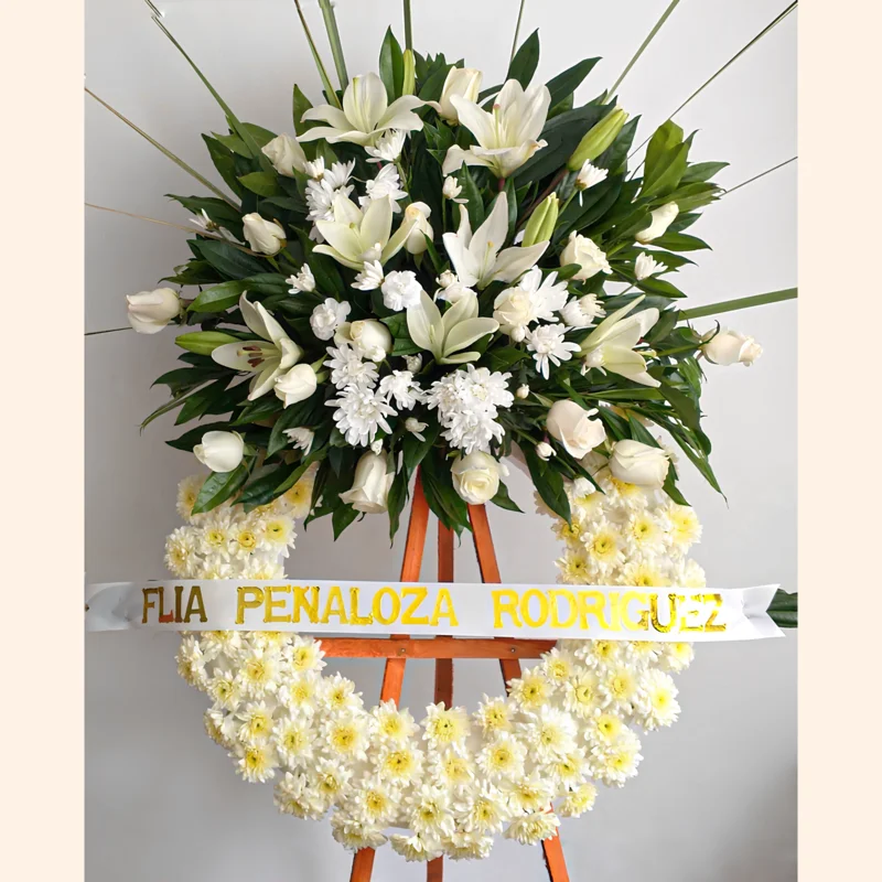 Elegante Corona Fúnebre con flores de condolencias; lirios, pompones y rosas blancas. Domicilio 100% gratis en todas las funerarias y salas de velación en Bogotá.