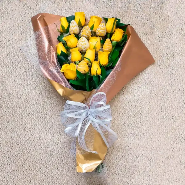 Bouquet de Flores Místico: rosas amarillas con fresas cubiertas de chocolate, envuelto en papel dorado con moño blanco.
