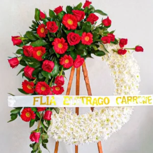 Corona fúnebre rosas rojas cascada abundante flores blancas follaje verde atril