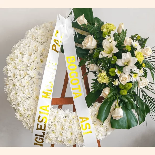 Elegante Corona de flores Fúnebres. Los lirios y sus rosas blancas transmiten esperanza. Su domicilio es gratis para Sepelios en Bogotá.