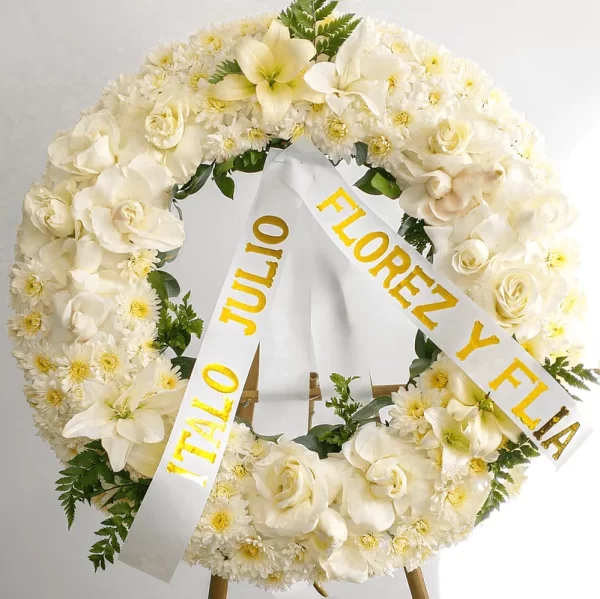 Simple, pero elegante Corona de Luto con diferentes flores blancas que simbolizan paz y expresan condolencias a los familiares del difunto en Bogotá.