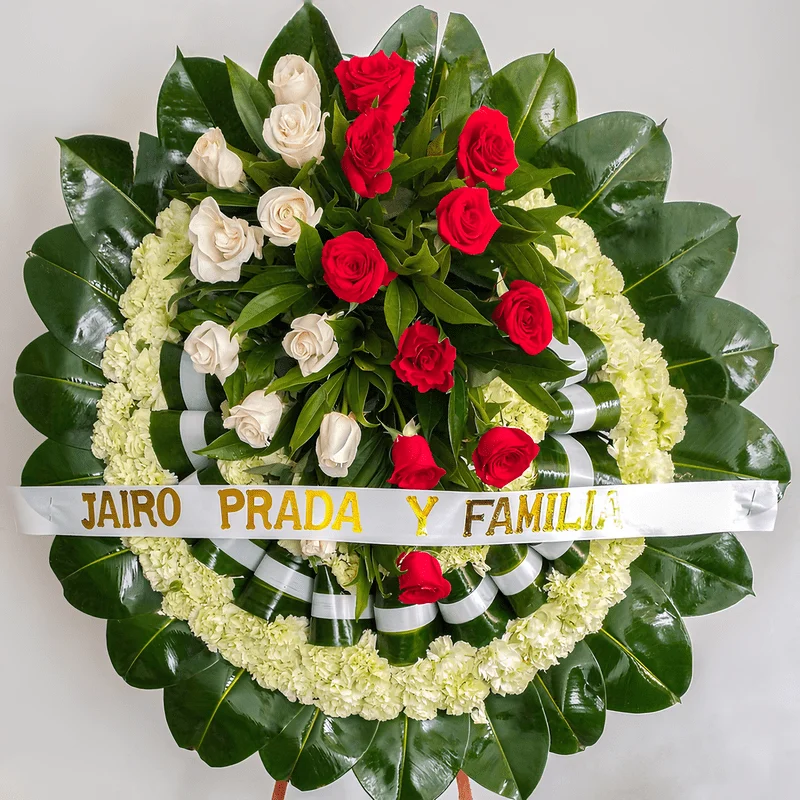 Elegante Corona Fúnebre llena de claveles, rosas blancas y rojas de luto para velorios de difuntos en Bogotá.