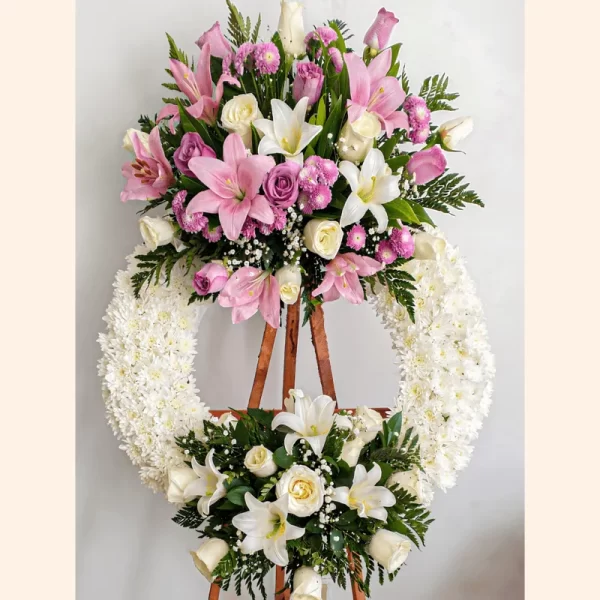 Elegante Corona Fúnebre con detalles rosas y blancos que transmiten paz y consuelo para velorios en Bogotá.
