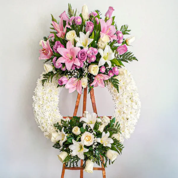 Corona de flores blancas crisantemos lirios rosados rosas lilas atril madera