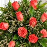Detalle de las rosas coral con caspia, helecho y hojas verdes de la Corona Fúnebre Memoria.