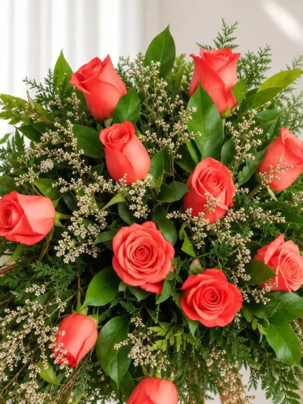 Detalle de las rosas coral con caspia, helecho y hojas verdes de la Corona Fúnebre Memoria.