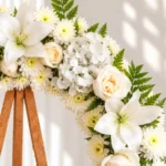 Detalle de la Corona Fúnebre Pureza: lirios blancos, rosas crema, hortensias y crisantemos blancos con helecho.