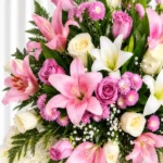 Detalle de la Corona Fúnebre Reencuentro: lirios rosados y blancos, rosas lila y blancas, pompones fucsia y gypsophila entre helecho.