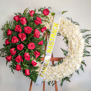 Corona de flores rosas rojas intensas flores blancas helechos verdes atril