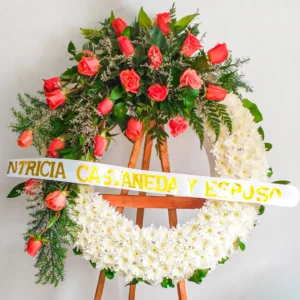 Coronas de flores blancas crisantemos rosas naranjas helechos cascada atril