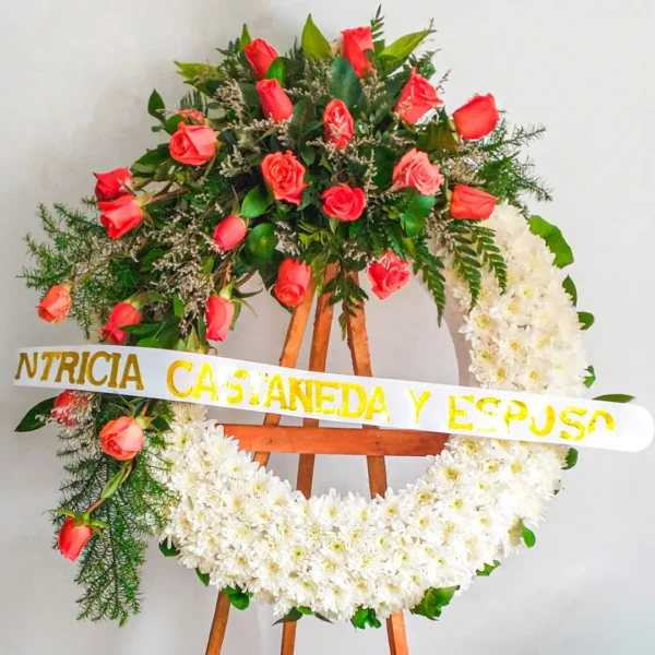 Coronas de flores blancas crisantemos rosas naranjas helechos cascada atril