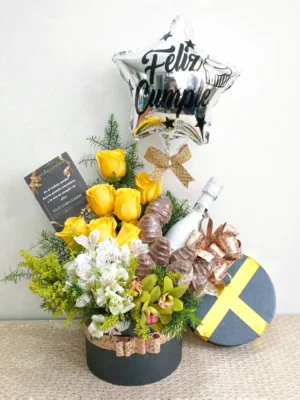 Ramo de cumpleaños con rosas amarillas, orquídeas verdes, astromelias blancas, globo metálico y vino en caja elegante.
