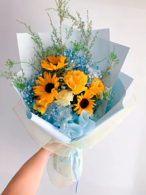 Bouquet de girasoles y rosas amarillas en Bogotá con flores en tonos azules, ideal para cumpleaños y baby showers