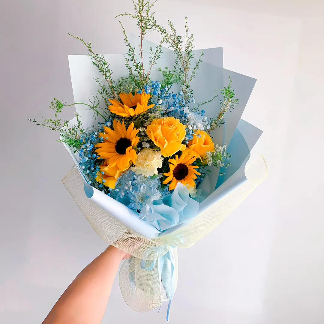 Bouquet de girasoles y rosas amarillas en Bogotá con flores en tonos azules, ideal para cumpleaños y baby showers