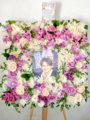 Arreglo fúnebre cuadrado con retrato enmarcado en flores rosadas, fucsia y moradas con crisantemos blancos
