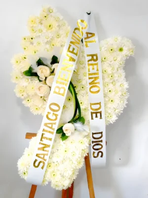 Arreglo fúnebre en forma de paloma con crisantemos y rosas blancas, y plumas decorativas
