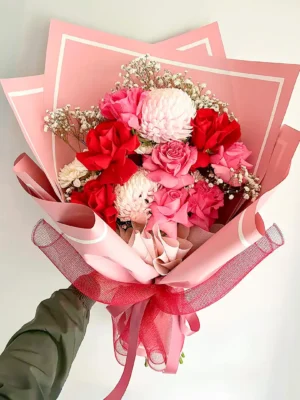 Bouquet de Flores Passionné con rosas rojas y rosadas, crisantemos y gypsophila, en papel rosado.