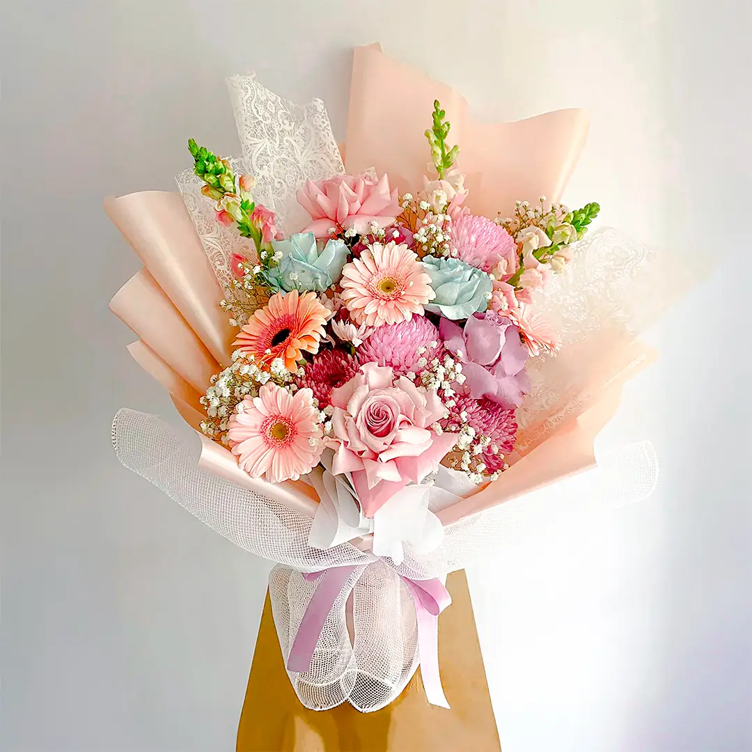 Bouquet de flores en tonos pastel con rosas rosadas, gerberas melocotón, crisantemos y gypsophila en Bogotá, ideal para baby showers y aniversarios