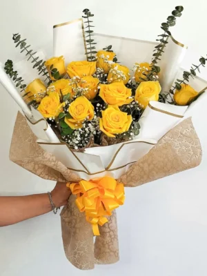 Bouquet de Flores Amour Jaune con rosas amarillas, eucalipto y gypsophila, en papel blanco con moño amarillo.