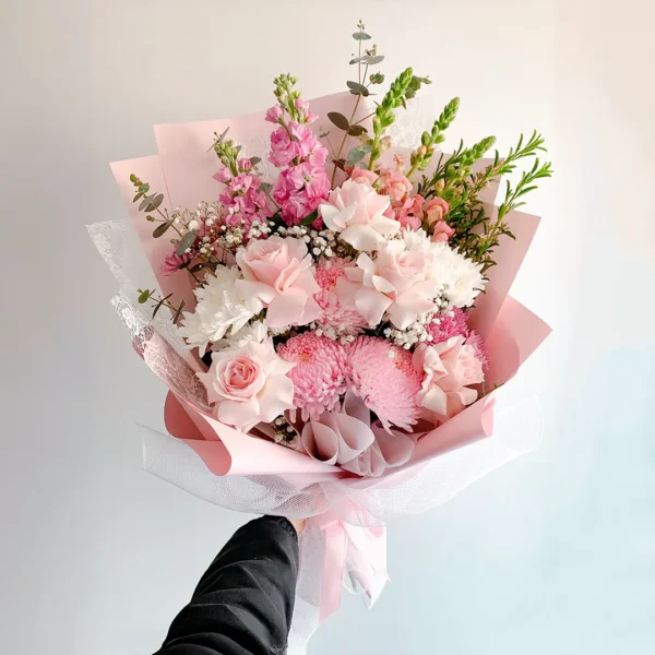 Bouquet de Flores Beauté con rosas rosadas, crisantemos rosados, claveles blancos y eucalipto, en papel rosado.