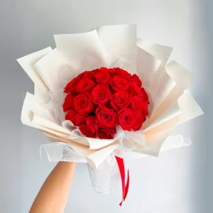 Bouquet de Flores Cramoisi, ramo buchón de rosas rojas en papel blanco.