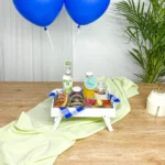 Desayuno sorpresa Aurore en caja madera con globos azules y productos gourmet