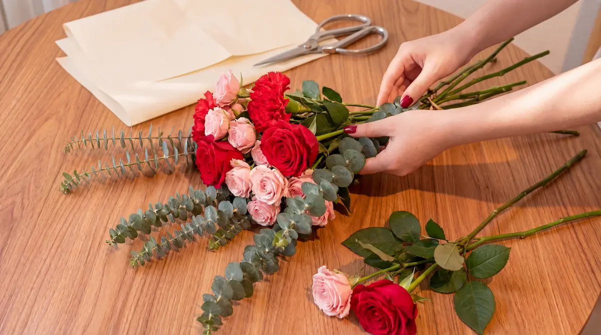 Floristería armando bouquet artesanal con flores frescas en Bogotá